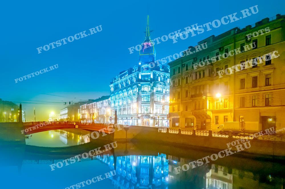 Освещенные здания и отражения в воде создают атмосферу ночного города. Фотография подходит для использования в туристических материалах, статьях о Санкт-Петербурге и иллюстрациях о ночной жизни города.